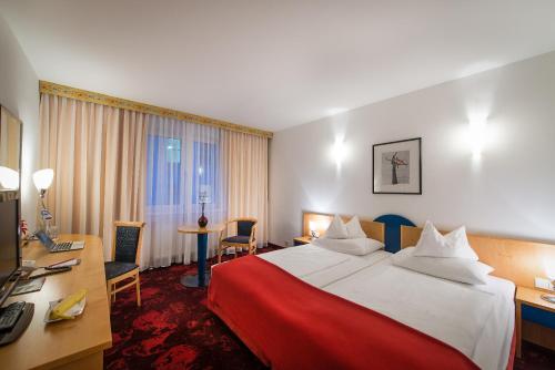 维也纳玻尔兹曼酒店的酒店客房设有一张大床和一张书桌。