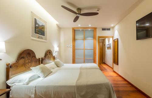 利亚内斯唐帕克酒店的一间卧室配有一张大床和吊扇