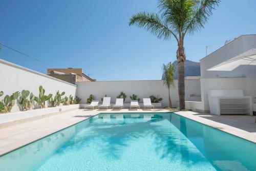 圣维托罗卡波Il Moro Camere&Relax的棕榈树房子后院的游泳池