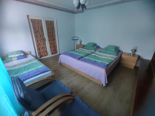 莫劳豪洛姆Abigél Apartman的一间卧室配有两张床和椅子