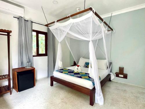 南威Gaia Villas的一间卧室配有一张带泰迪熊的天蓬床。