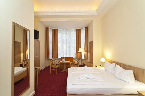 柏林柏林库尔菲尔斯腾维瓦尔第酒店的酒店客房配有一张床铺和一张桌子。