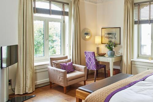 汉堡Das Elbcottage - Remise am Süllberg - Boarding House的酒店客房,配有一张床、一张桌子和椅子