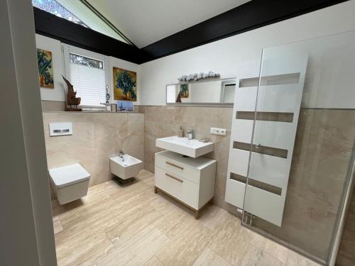 海肯多夫Gemütliches Haus zwischen Förde und Golfplatz的一间带两个盥洗盆、淋浴和卫生间的浴室