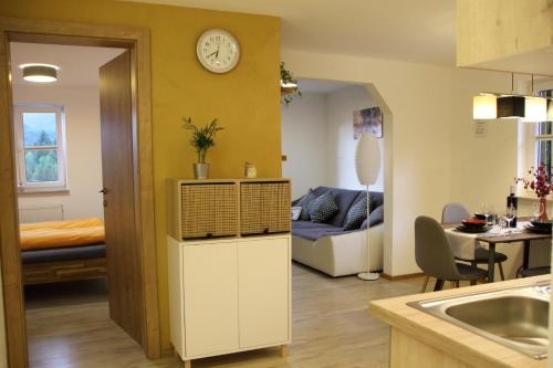巴德哥依斯恩弗瑞恩豪斯库尔维恩酒店的厨房以及带沙发和时钟的客厅。