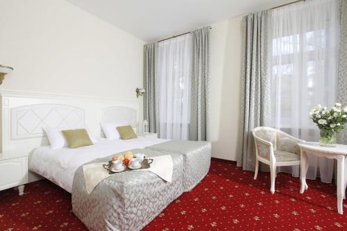 卢布林拉文多沃尔克度假村的酒店客房设有一张大床和一张桌子。