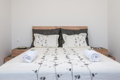 萨摩斯Blue Garden Samos Apartments的卧室配有一张带白色床单和枕头的大床。