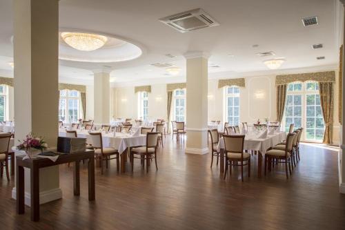 奥尔库什迪沃勒瑞克纳德罗斯路易斯弗恩酒店的用餐室设有桌椅和窗户。