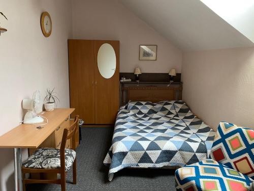 维尔纽斯Valentina's Rooms的一间卧室配有一张床、一张桌子和一把椅子