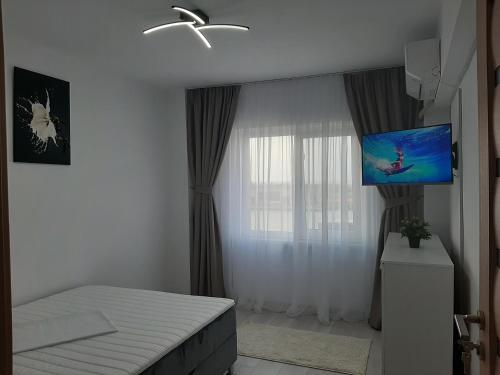 苏利纳Apartament DeltaView Deluxe Sulina的一间卧室配有一张床和一台平面电视