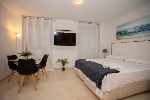 阿利坎特Apartamentos Rafael Loft的卧室配有一张床和一张桌子及椅子