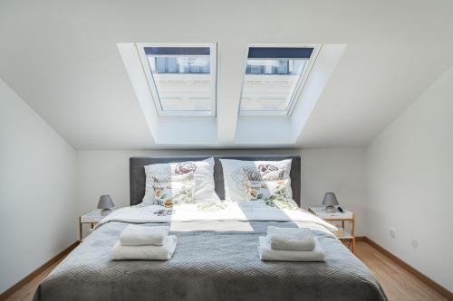 维也纳City Lodge Vienna的一间卧室设有一张大床和两个窗户