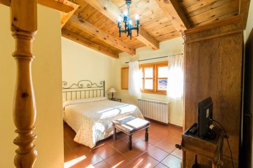 GalveCasa Rural La Yedra的一间卧室配有一张床和一台电视。