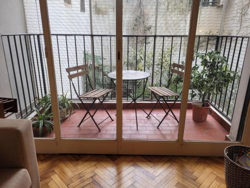 布宜诺斯艾利斯Recoleta Time的阳台的天井配有2把椅子和1张桌子