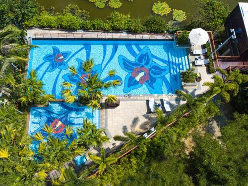 三亚三亚亚龙湾星华套房假日酒店的游泳池的顶部景色,上面有画作