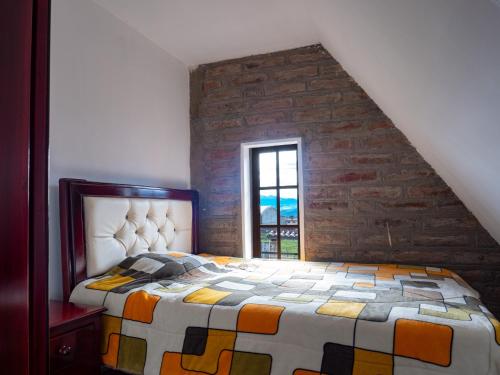 MachachiMateospaxi的一间卧室设有一张床和砖墙