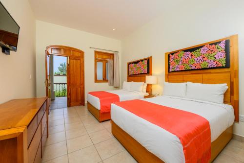 瓦哈卡市埃克斯题鲁成人酒店 的酒店客房设有两张床和电视。