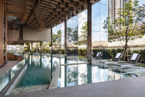 暖武里府Oakwood Suites Tiwanon Bangkok的一座大楼中央的游泳池