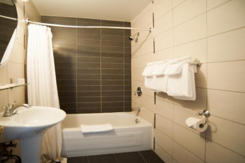 Saint-Basile-le-Grand海市蜃楼酒店的一间带水槽、浴缸和卫生间的浴室