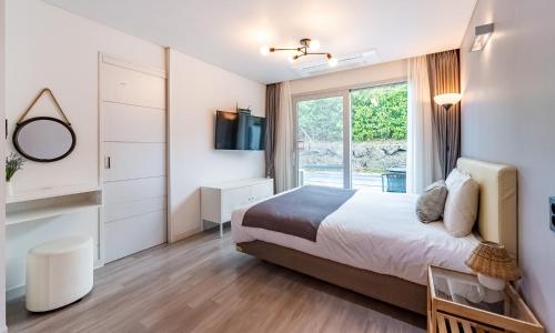 济州市索朗泳池别墅的一间卧室设有一张大床和一个窗户。