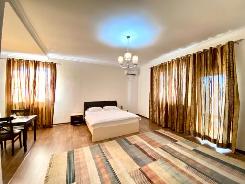 阿特劳萨莱巴图旅馆的一间卧室配有一张床、一张桌子和一张桌子