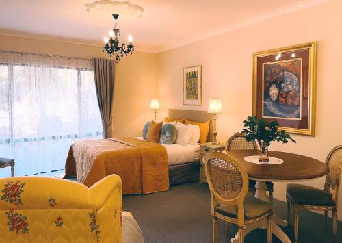 玛格丽特河紫檀木宾馆的酒店客房带一张床、一张桌子和椅子