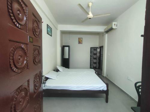PonnāniJinnens Tourist Home的一间卧室配有一张床和吊扇