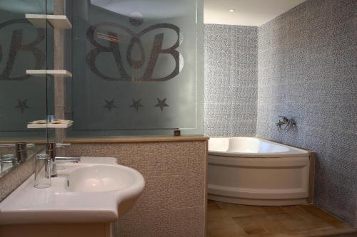纳布勒拜占庭酒店的一间带水槽、浴缸和卫生间的浴室