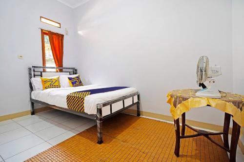 伦邦OYO Life 91469 Pondok Pelita的一间卧室配有一张床和一张带台灯的桌子