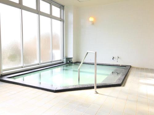 伊东ISOLA Izukogen的一个带大窗户的房间内的游泳池