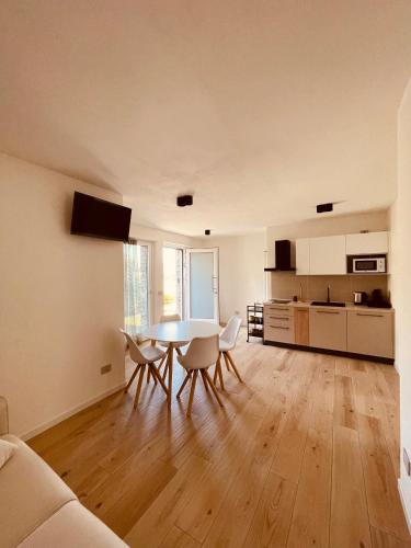 Berbenno di ValtellinaTellure apartments with breakfast的一间带桌椅的客厅和一间厨房