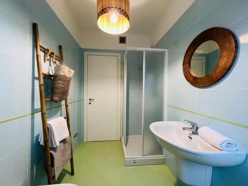 锡尔维玛丽娜Beach apartments Spiaggia Nascosta的一间带水槽、镜子和淋浴的浴室