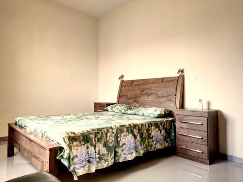 普拉亚Praia Capital Residence Aparthotel的一间卧室配有木床和木制梳妆台
