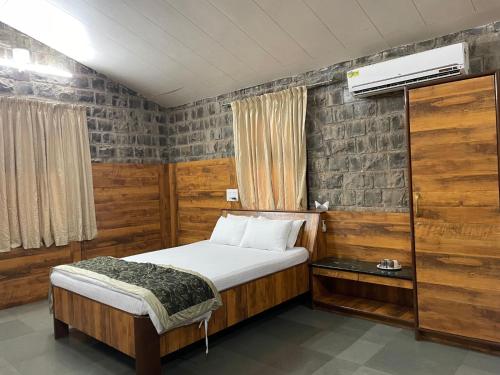 浦那The Green Gate Resort Mulshi的一间小卧室,配有床和窗户