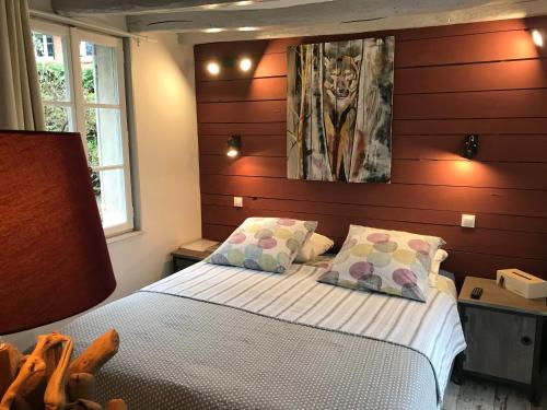 塔罗讷河畔绍蒙La tanière des ours的卧室配有一张床,墙上挂有绘画作品