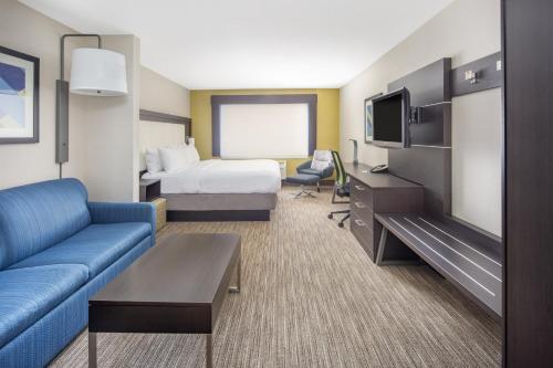毕夏普毕夏普套房智选假日酒店的酒店客房设有沙发、床和电视。