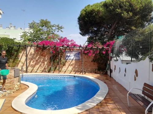 蓬塔翁布里亚Casa Marquesa的一座游泳池,位于一个拥有粉红色花卉的庭院内