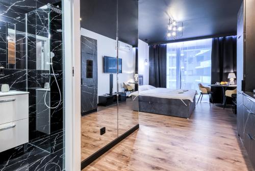 华沙Wola Luxury Stay的一间卧室配有一张床,浴室设有淋浴。