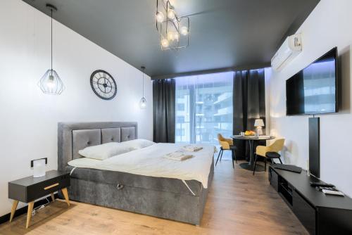 华沙Wola Luxury Stay的一间卧室配有一张床和一张书桌,还有一间用餐室