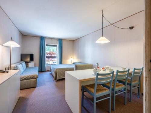 普雷圣迪迪埃Apartment Universo-1 by Interhome的酒店客房设有桌椅和一间卧室。