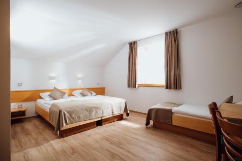 斯洛文尼亚比斯特里察Gostišče Iršič的酒店客房设有两张床和窗户。