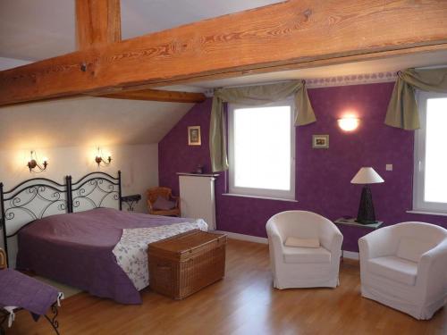 Biernegite du chêne的一间卧室设有紫色的墙壁和一张床及椅子