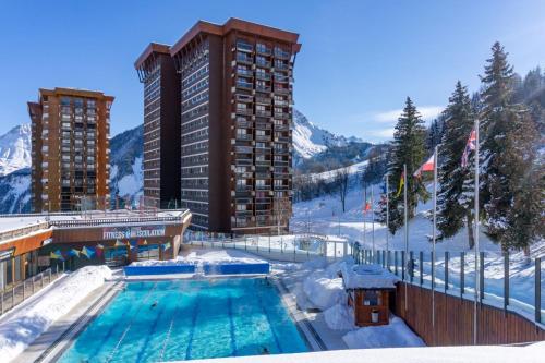 维拉伦贝特Appartement avec balcon au pied des pistes de ski的建筑物旁边的雪地游泳池