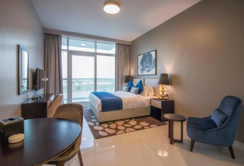 迪拜Premium Studio with Beautiful Golf Course View的酒店客房带一张床、一张桌子和椅子