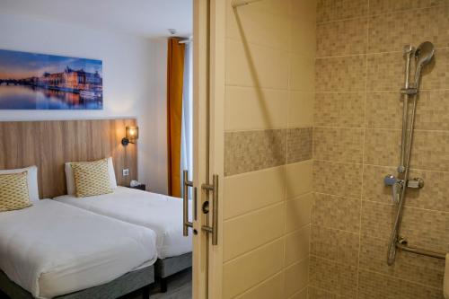 巴黎基里雅德巴黎10号圣马丁运河共和国酒店的酒店客房配有一张床和淋浴