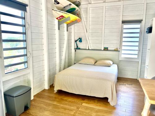 德赛Le Surf Lodge, chambre avec vue mer dans un écrin de verdure的一间小卧室,配有床和窗户