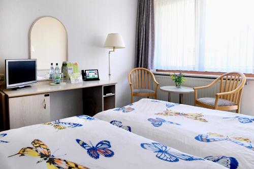 CursdorfHotel Im Kräutergarten的酒店客房配有两张床和一张书桌