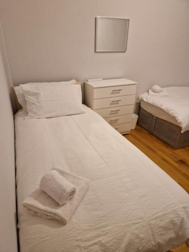 伦敦A Beautiful place的一间卧室配有两张床和一个带毛巾的梳妆台。