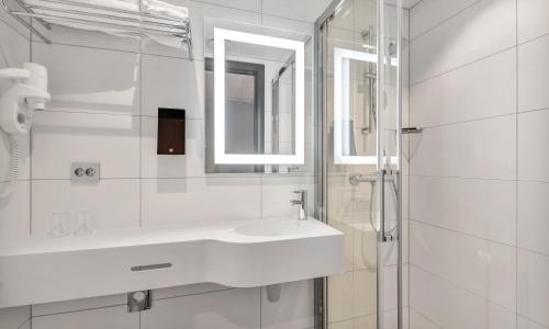 特罗姆瑟泼乐松恩酒店的白色的浴室设有水槽和镜子