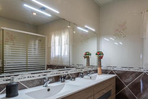 罗列特海岸Villa Maria的一间带两个盥洗盆和大镜子的浴室